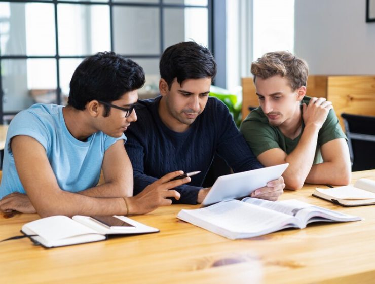 focused-students-using-tablet-discussing-information_1262-14929
